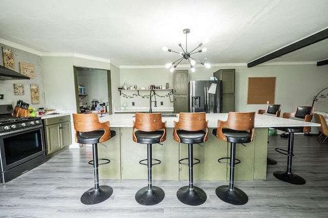 kitchen with a breakfast bar area, crown molding, light wood-type flooring, appliances with stainless steel finishes, and an island with sink