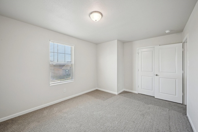 unfurnished bedroom with carpet and a textured ceiling