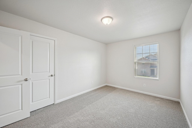 carpeted spare room with a textured ceiling