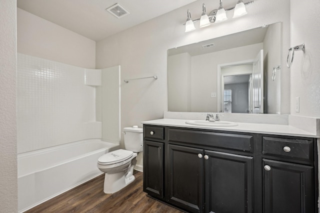 full bathroom featuring vanity, hardwood / wood-style flooring, shower / washtub combination, and toilet