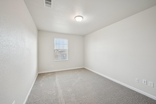 carpeted spare room with a textured ceiling