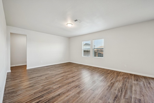 empty room with dark hardwood / wood-style flooring