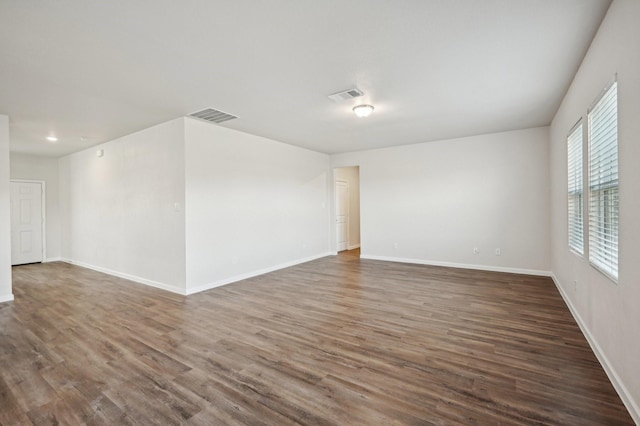 unfurnished room with dark wood-type flooring