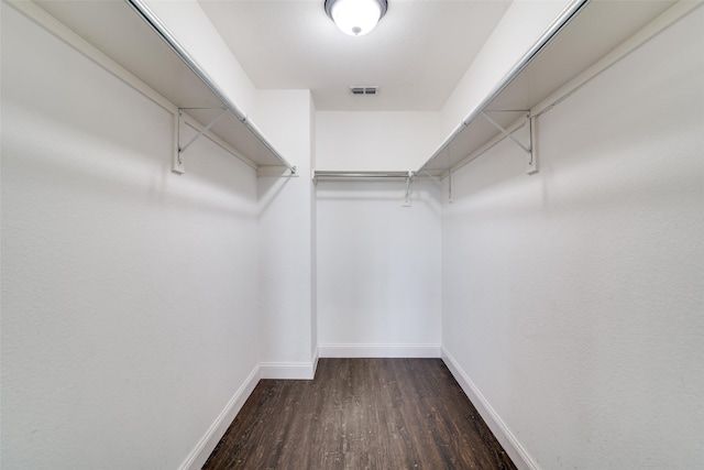 spacious closet with dark hardwood / wood-style flooring