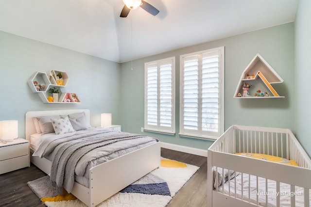 bedroom featuring ceiling fan, dark hardwood / wood-style flooring, and vaulted ceiling