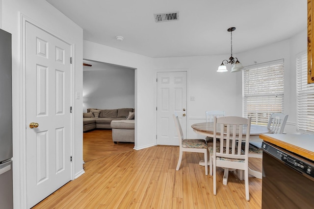 dining space with an inviting chandelier and light wood-type flooring