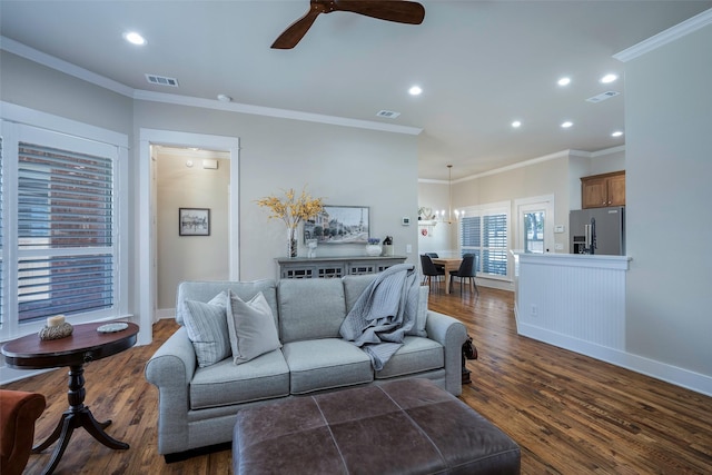 living room with crown molding, dark hardwood / wood-style floors, and ceiling fan with notable chandelier