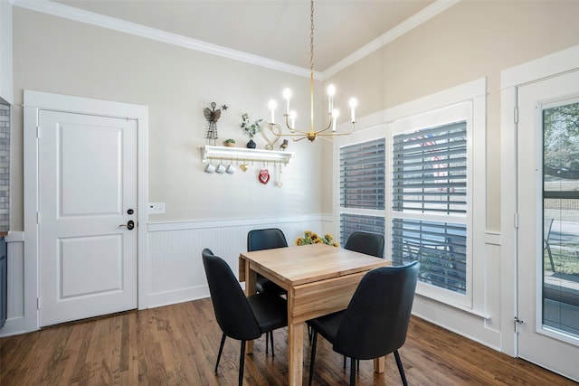 dining space featuring hardwood / wood-style flooring, ornamental molding, and an inviting chandelier