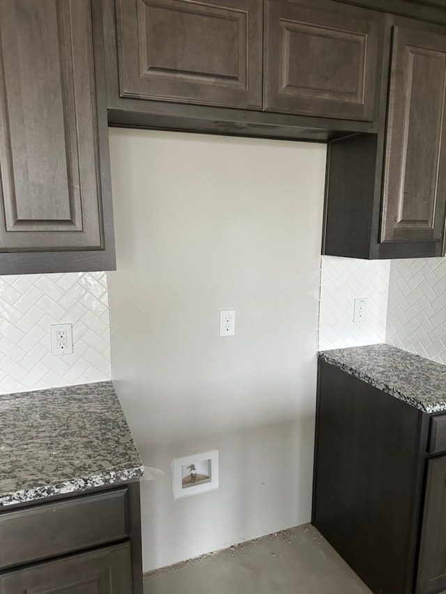 kitchen featuring tasteful backsplash, dark brown cabinets, and stone countertops