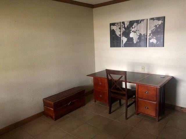 office area with dark tile patterned floors and crown molding