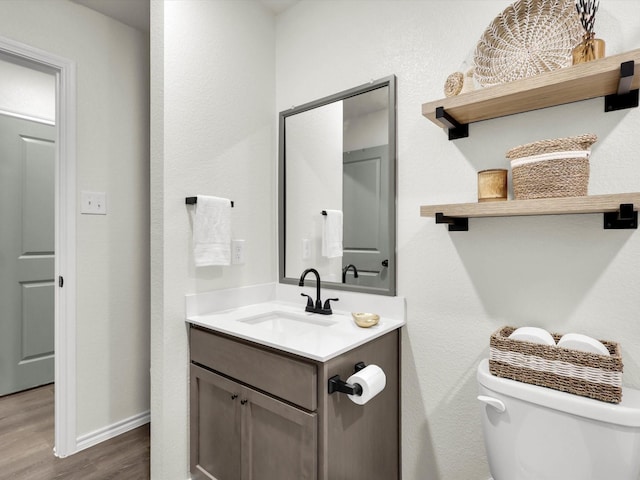 bathroom with vanity, hardwood / wood-style floors, and toilet