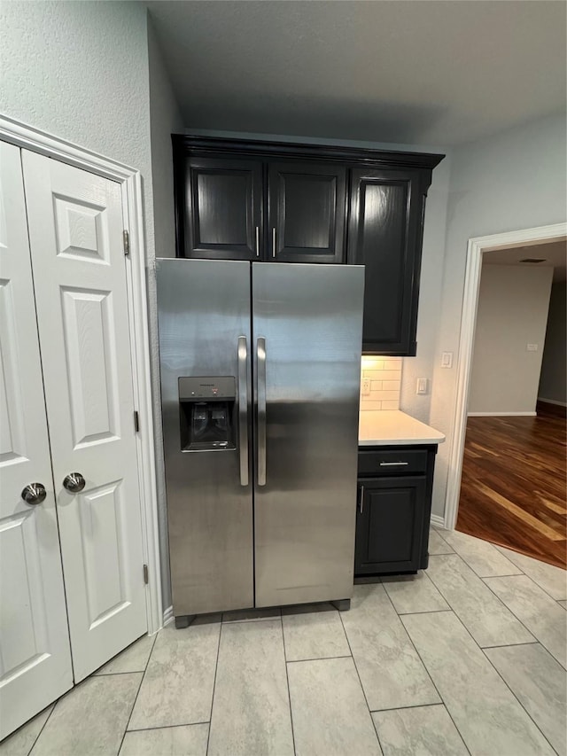 kitchen with decorative backsplash and stainless steel fridge with ice dispenser