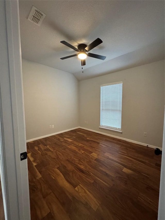 unfurnished room with ceiling fan, lofted ceiling, dark wood-type flooring, and a textured ceiling