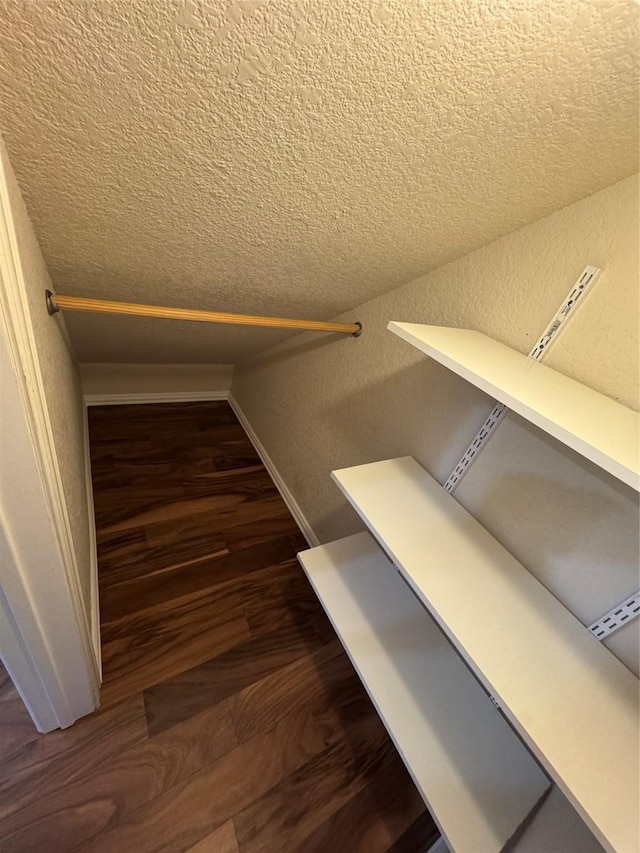 walk in closet featuring dark wood-type flooring