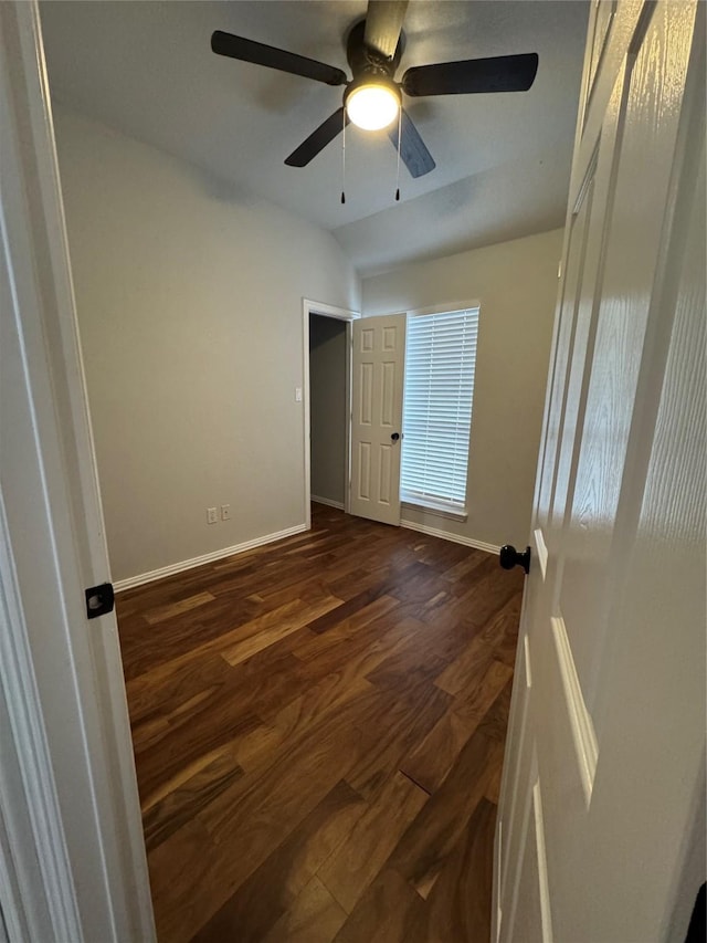 unfurnished bedroom with lofted ceiling, dark hardwood / wood-style floors, and ceiling fan