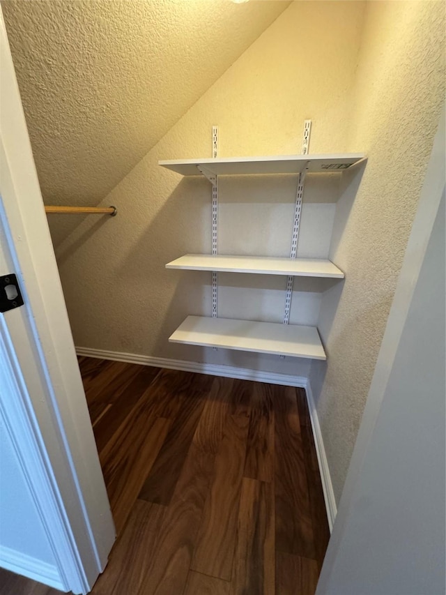 spacious closet featuring hardwood / wood-style flooring and lofted ceiling