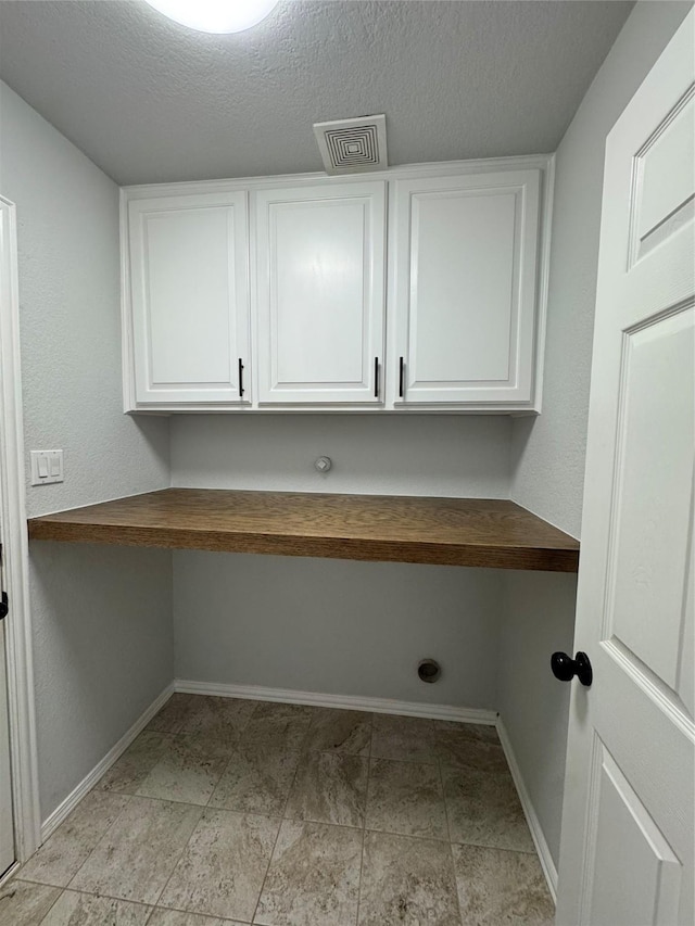 laundry area with a textured ceiling