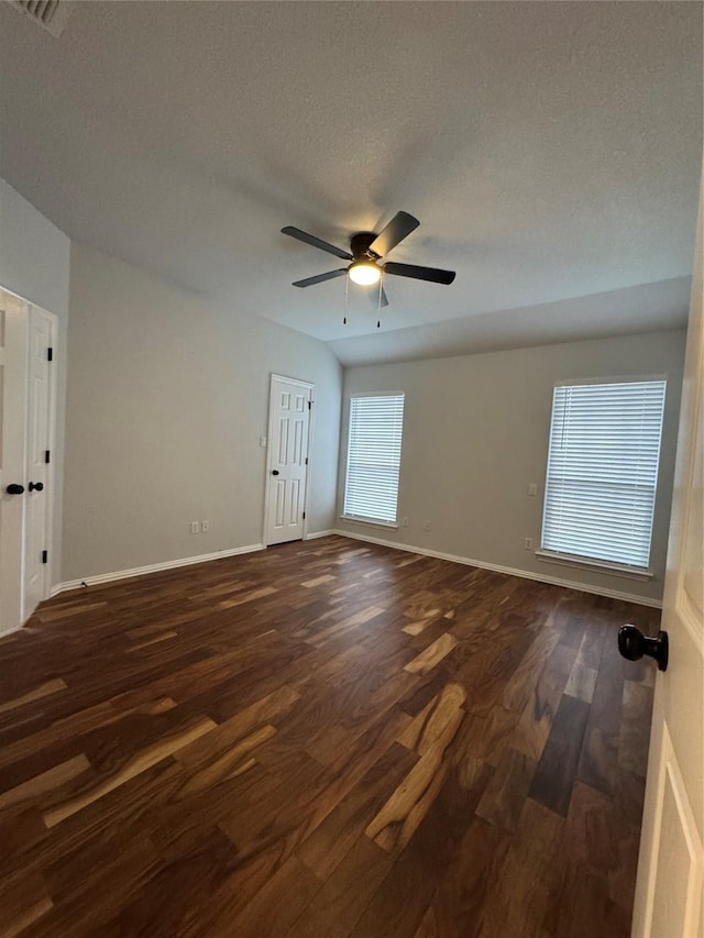 spare room with a textured ceiling, dark wood-type flooring, and ceiling fan