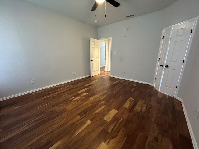 empty room featuring ceiling fan and dark hardwood / wood-style flooring