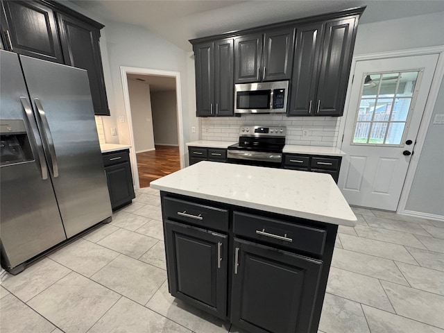 kitchen with lofted ceiling, stainless steel appliances, decorative backsplash, and light tile patterned floors