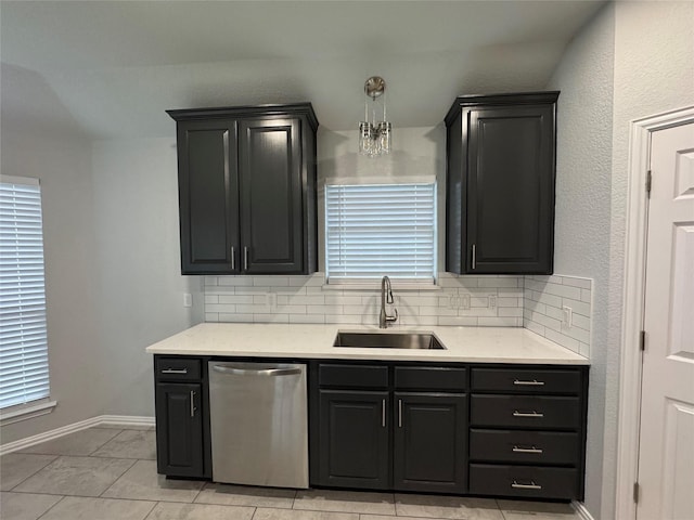 kitchen featuring hanging light fixtures, dishwasher, sink, and decorative backsplash