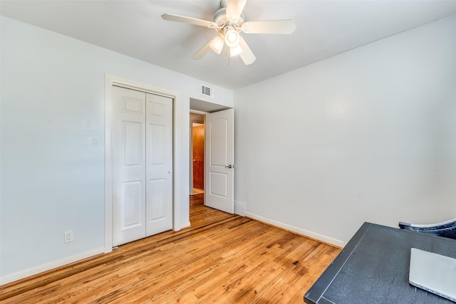 unfurnished bedroom featuring ceiling fan, light wood-type flooring, and a closet