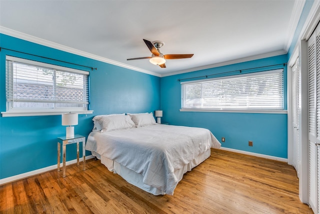 bedroom with multiple windows, crown molding, and light wood-type flooring