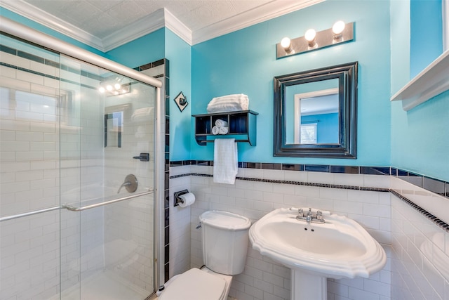 bathroom with walk in shower, toilet, sink, crown molding, and tile walls