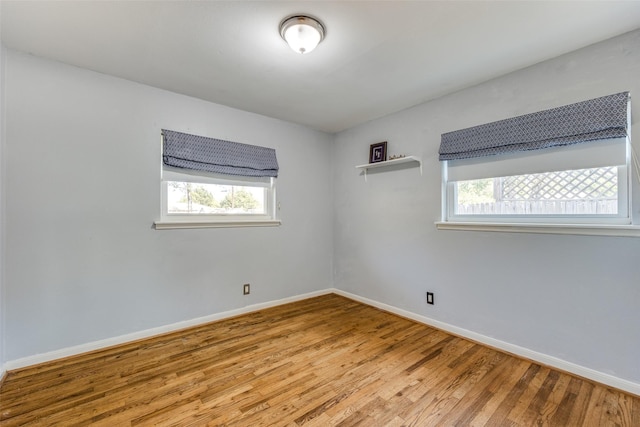 spare room with hardwood / wood-style flooring and plenty of natural light