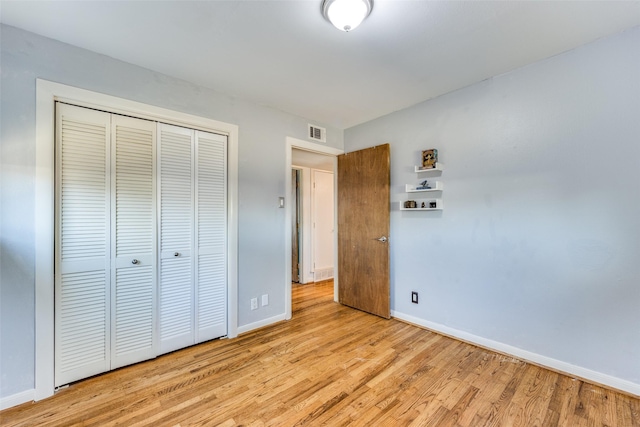 unfurnished bedroom with a closet and light wood-type flooring