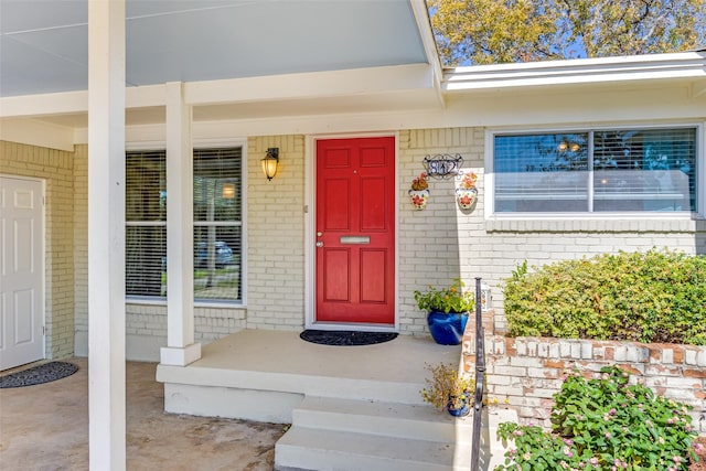 view of exterior entry featuring covered porch