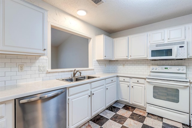 kitchen featuring white cabinetry, sink, backsplash, and white appliances