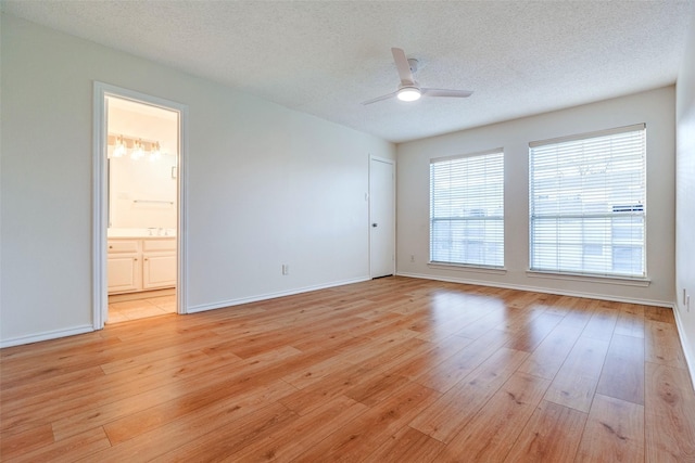 unfurnished room featuring ceiling fan, a textured ceiling, and light wood-type flooring