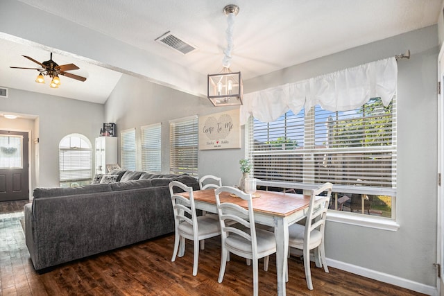 dining room with lofted ceiling, dark wood-type flooring, and ceiling fan with notable chandelier