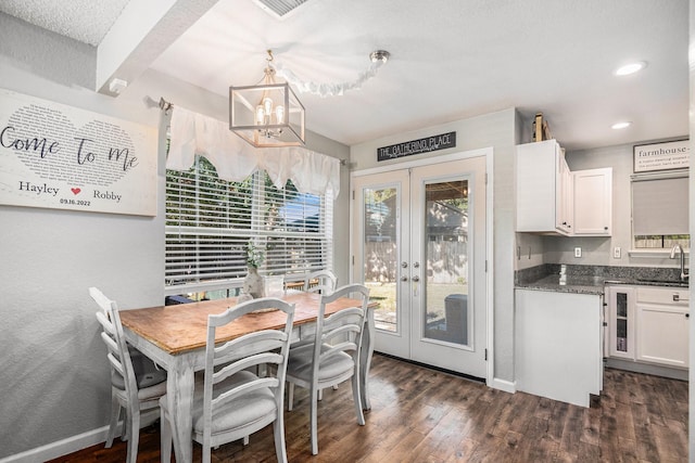 dining space with french doors, dark hardwood / wood-style floors, sink, and a notable chandelier