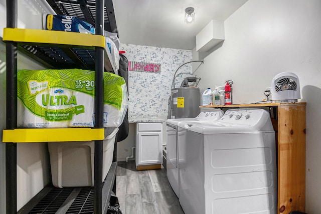 laundry room featuring cabinets, light wood-type flooring, independent washer and dryer, and water heater