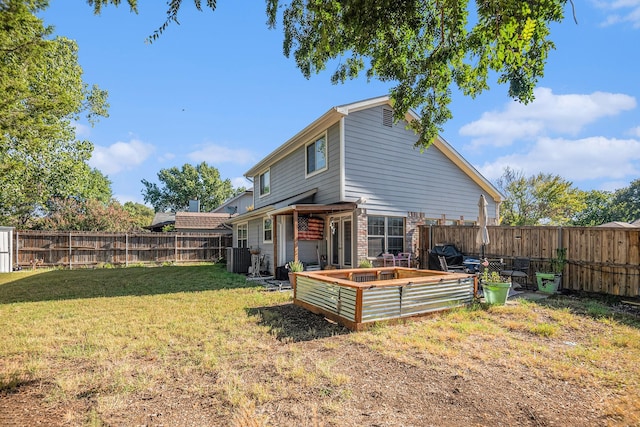 back of property with a yard and central AC unit