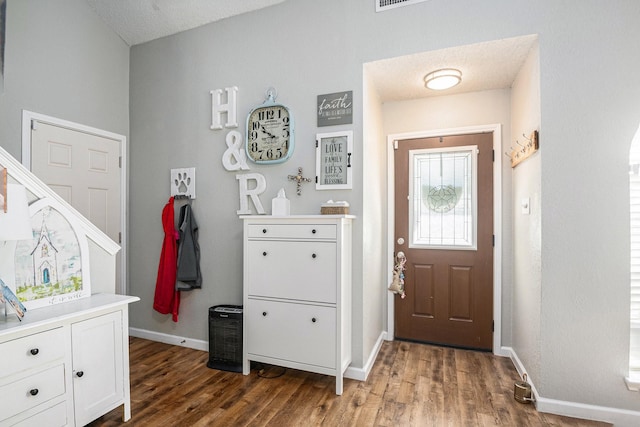 foyer entrance featuring dark hardwood / wood-style floors and a textured ceiling