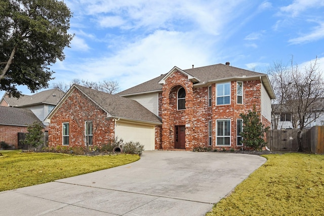 traditional-style house featuring a garage, concrete driveway, fence, a front lawn, and brick siding