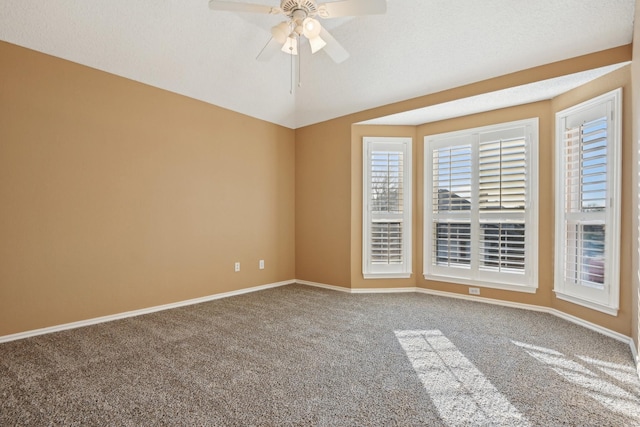 carpeted empty room featuring lofted ceiling, a ceiling fan, and baseboards