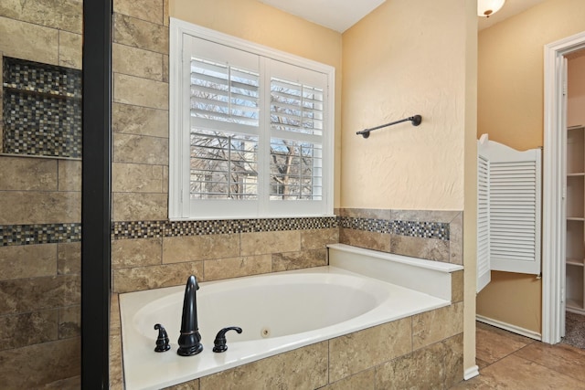 bathroom featuring a relaxing tiled tub and tile patterned floors