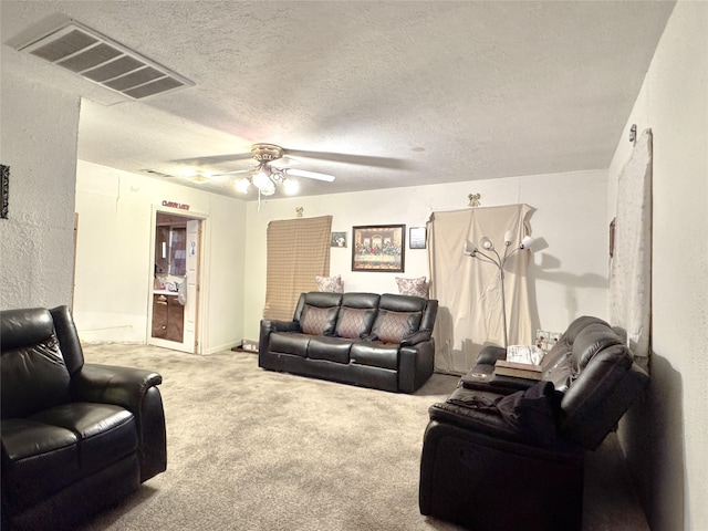 living room with ceiling fan, a textured ceiling, and carpet