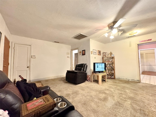 carpeted living room featuring ceiling fan and a textured ceiling