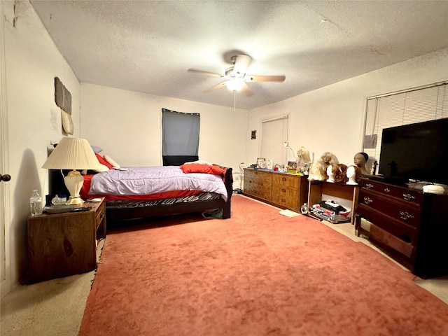 carpeted bedroom with ceiling fan and a textured ceiling