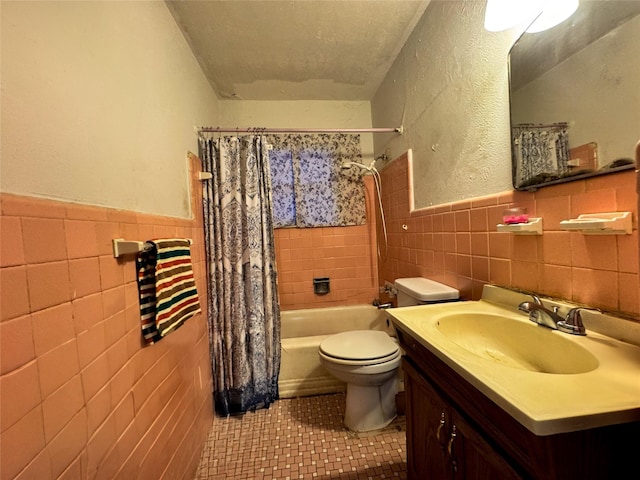 full bathroom with tile walls, vanity, toilet, shower / bath combo, and tile patterned floors