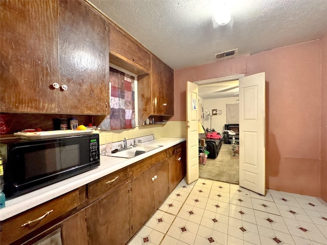 kitchen with sink and a textured ceiling