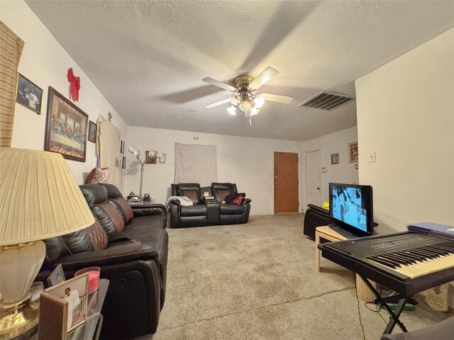 living room featuring a textured ceiling, carpet floors, and ceiling fan