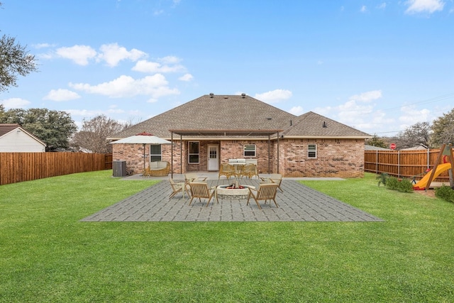 back of property with a yard, a patio, and a playground