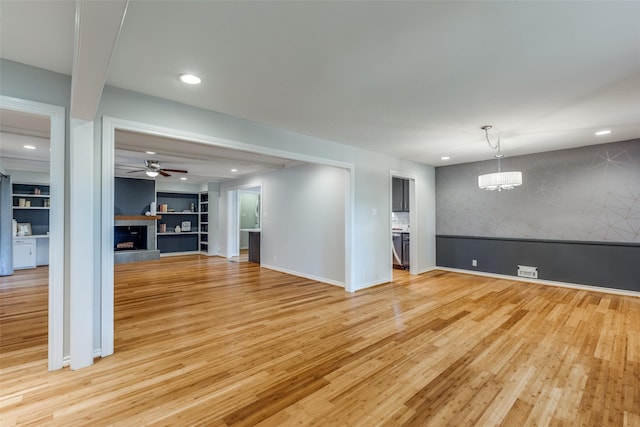 unfurnished living room featuring ceiling fan and light wood-type flooring