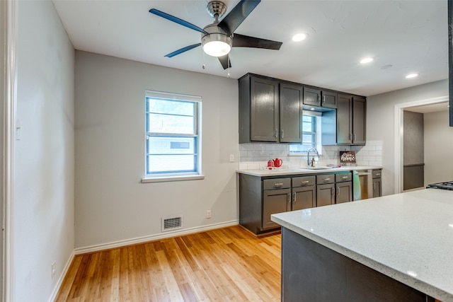 kitchen featuring dishwasher, sink, decorative backsplash, ceiling fan, and light wood-type flooring